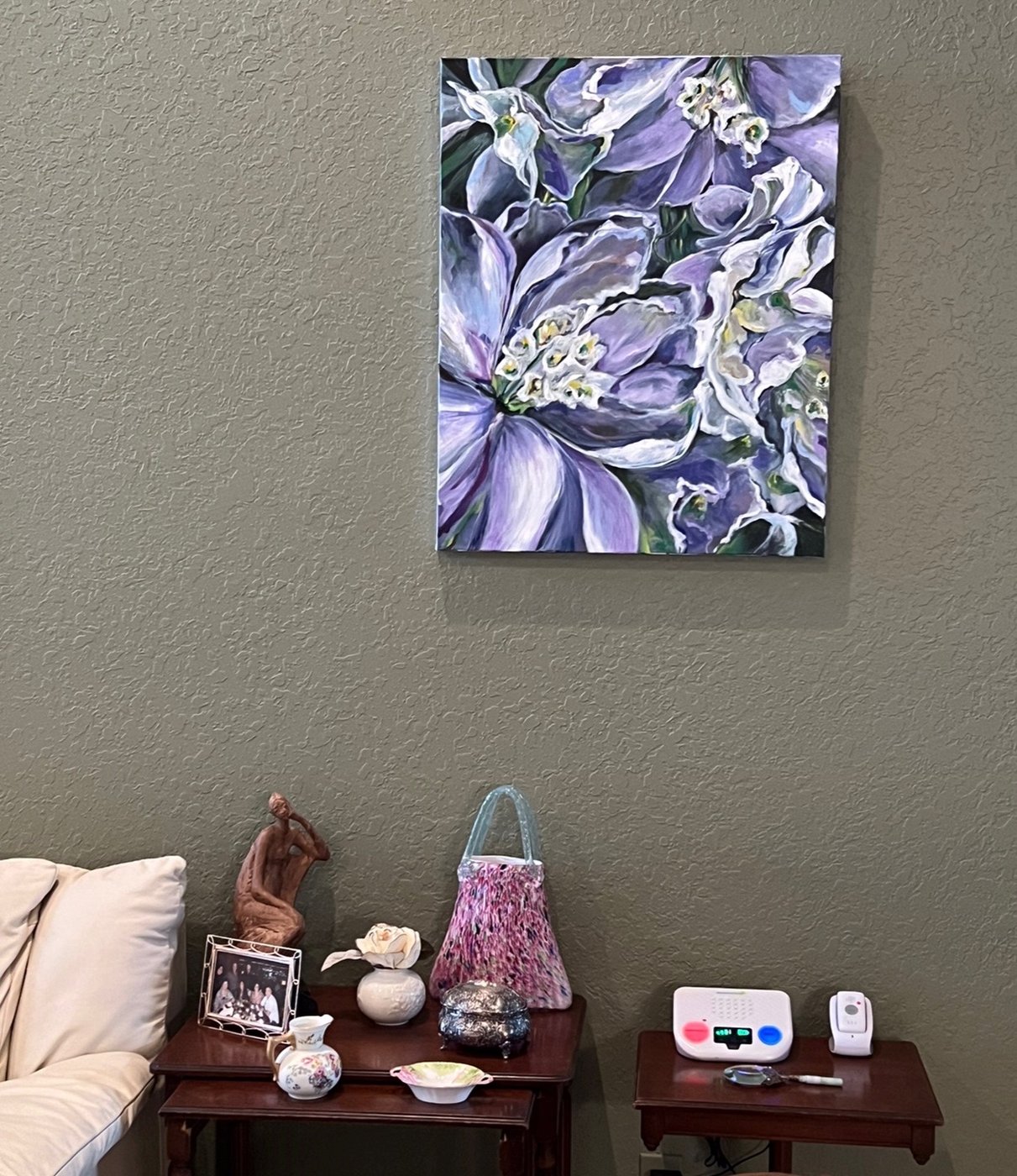 Purple floral painting hung in a home