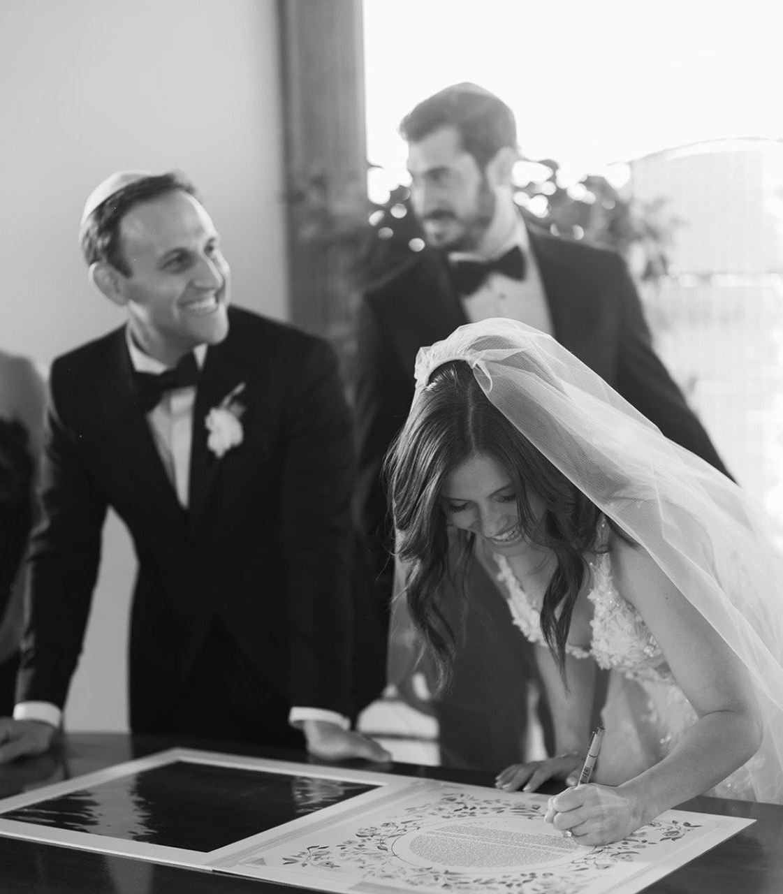 Bride signing her ketubah at a Jewish wedding